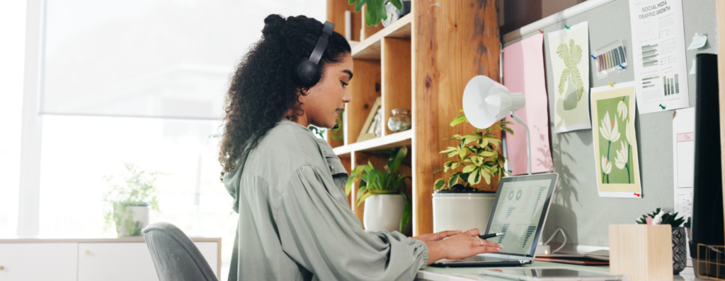 Woman studying online at her laptop while completing a TEFL course, illustrating how long does a TEFL course take.