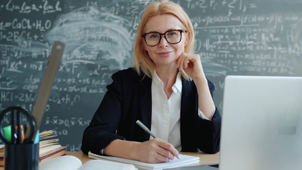Smiling TEFL teacher at a laptop researching a free AI certificate for teachers