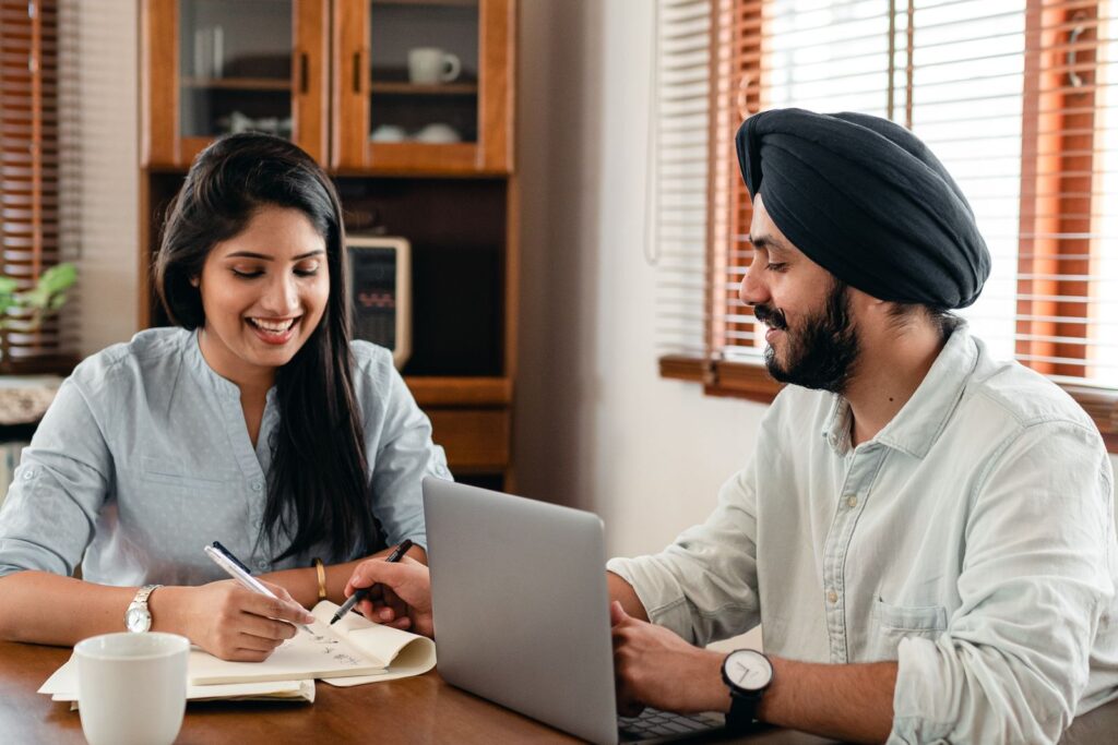A couple studying together on a laptop at home