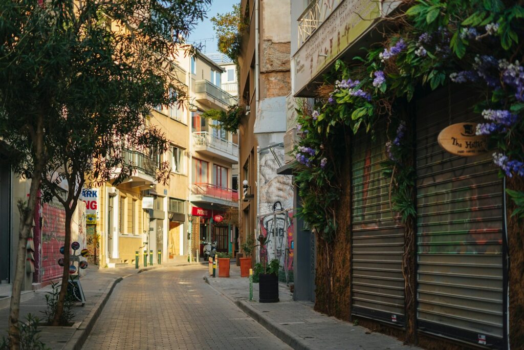 Narrow Greek city street lined with tall apartment blocks housing language centres