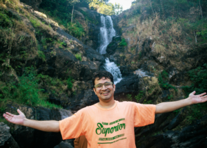 Happy teacher enjoying a day trip to a waterfall during time off from teaching English in Spain