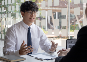 Graduate reviewing TEFL interview preparation guide and questions on a laptop